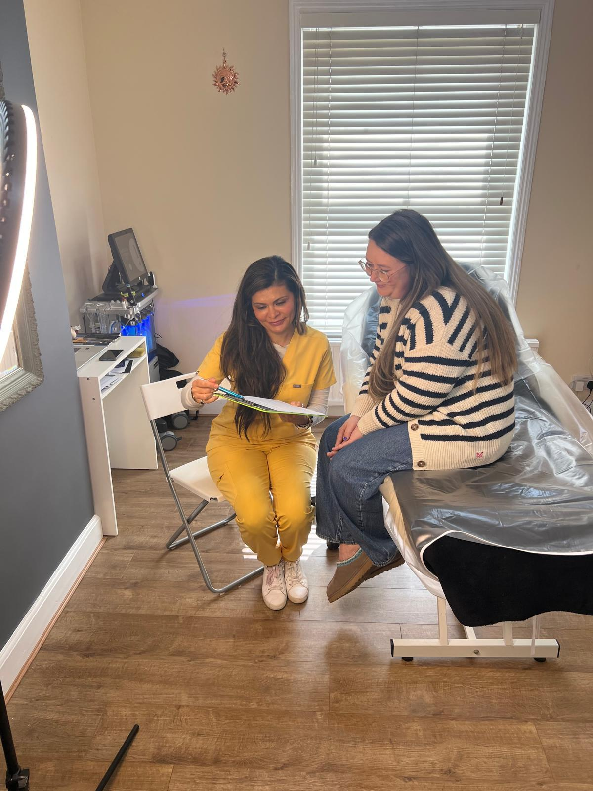 Het consulting with a client during an aesthetic treatment at HHM Clinics